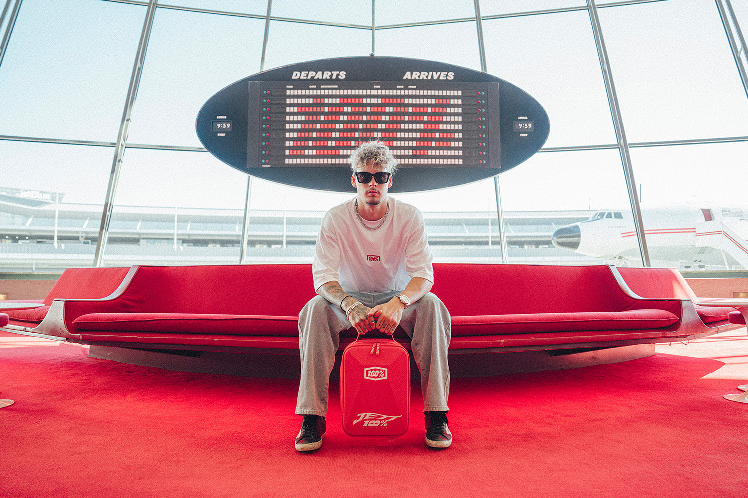 American Motocross Pro Athlete Jett Lawrence Sitting at the airport holding the 100Percent® Limited Edition Armega JettPak case