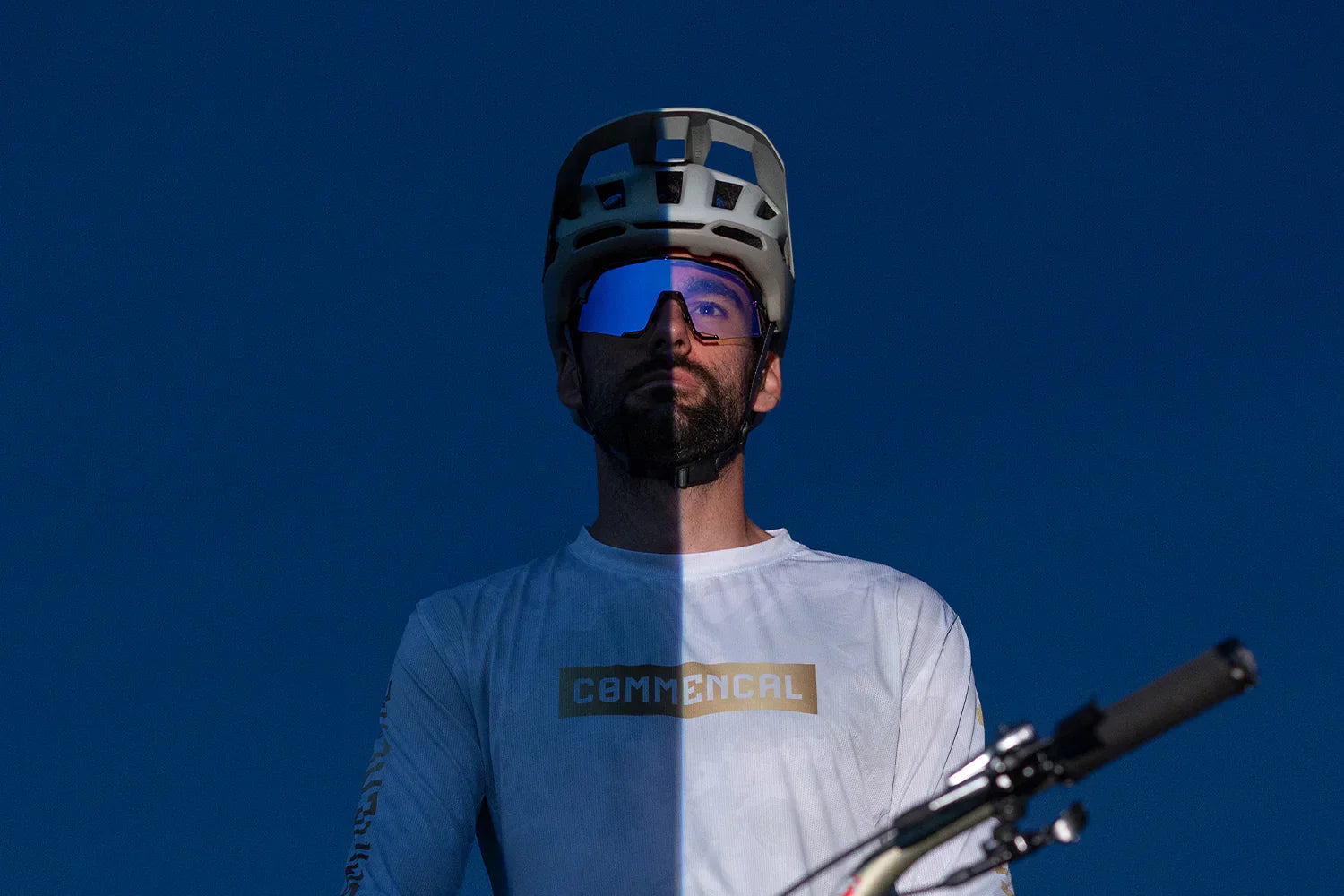 100Percent® Photochromic Education featuring Kilian Bron with the SLENDALE® Gloss Black Purple Mirror Photochromic Lens half dark, half light showing the Photochromic lens
