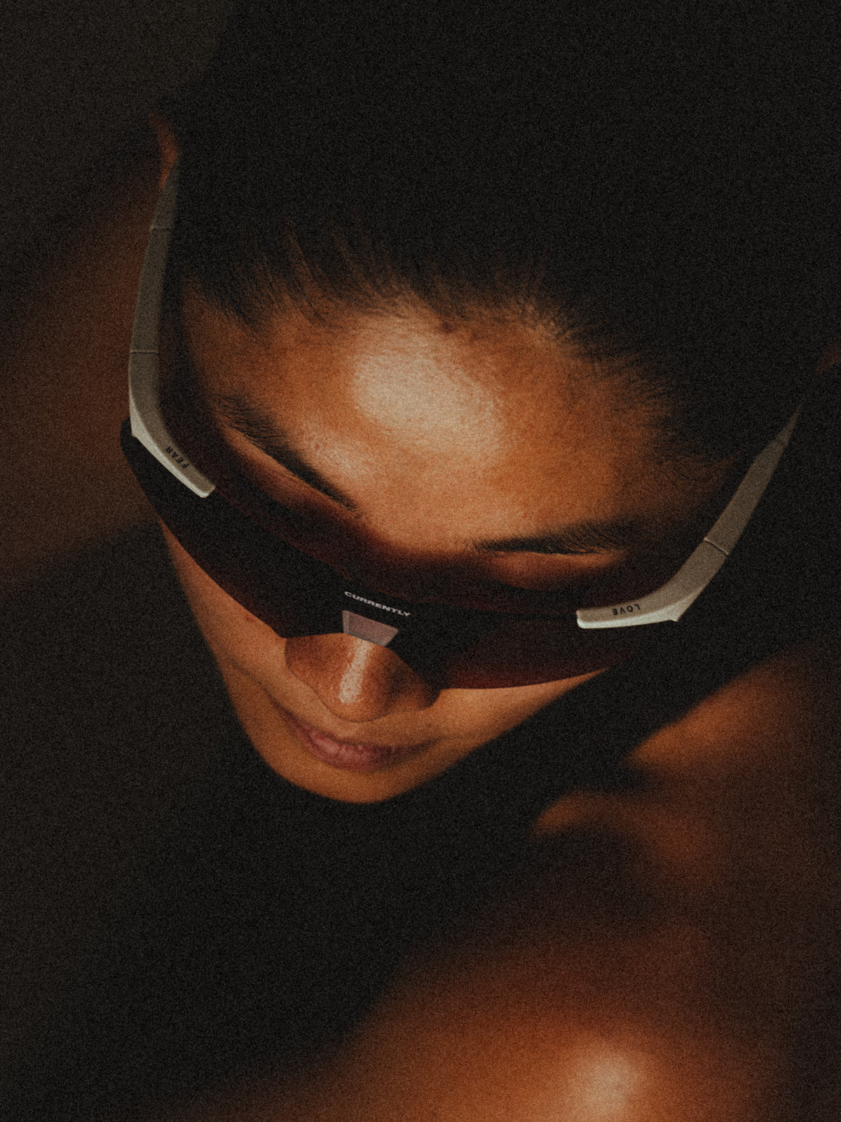 Currently Running™ x 100Percent® Collection - Featuring a girl runner wearing a Currently Running top and 100Percent A2 Sunglasses on a dark-warm moody background.