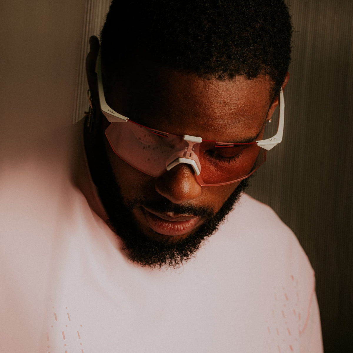 Currently Running™ x 100Percent® Collection - Featuring a male runner wearing a Currently Running top and 100Percent Hypercraft® SQ Sunglasses on a dark-warm moody background.